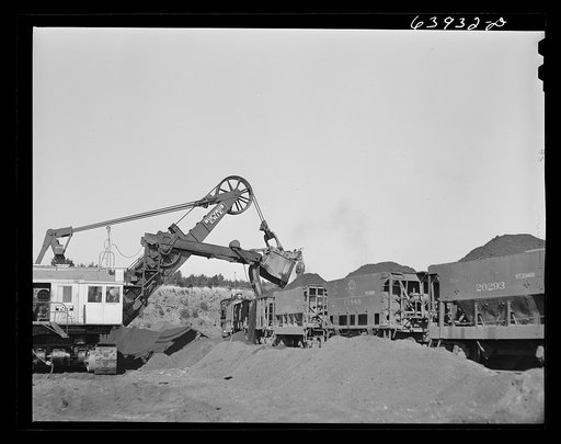 Untitled photo, possibly related to: Electric shovel loading iron ore into railroad cars, eight cubic yards per shovelful. Mahoning Mine. Hibbing, Minnesota