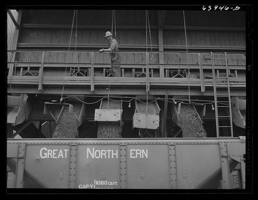 Washed ore being loaded into seventy ton cars for shipment to Duluth-Superior ore docks. Concentration plant at Bovey, Minnesota