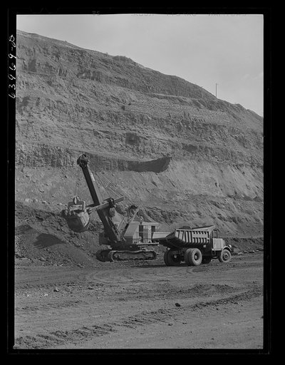 Loading truck with iron ore at the Albany mine near Hibbing, Minnesota. Use of trucks was initiated in this mine two years ago and railroad tracks removed