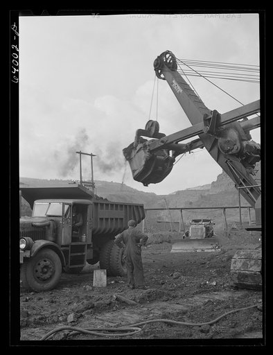 Untitled photo, possibly related to: Loading trucks with iron ore at the Albany mine, Hibbing, Minnesota. This mine formerly used railroad until trucks were found more economical; they can climb the steep grade in much shorter time