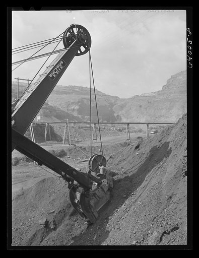 Untitled photo, possibly related to: Electric shovel loading iron ore into railroad cars, eight cubic yards per shovelful. Mahoning Mine. Hibbing, Minnesota