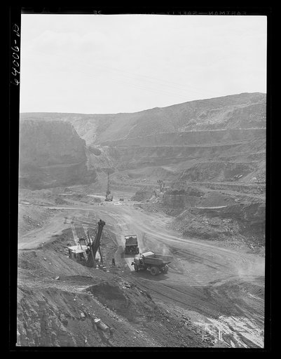 Untitled photo, possibly related to: Loading trucks with iron ore at the Albany mine, Hibbing, Minnesota. This mine formerly used railroad until trucks were found more economical; they can climb the steep grade in much shorter time
