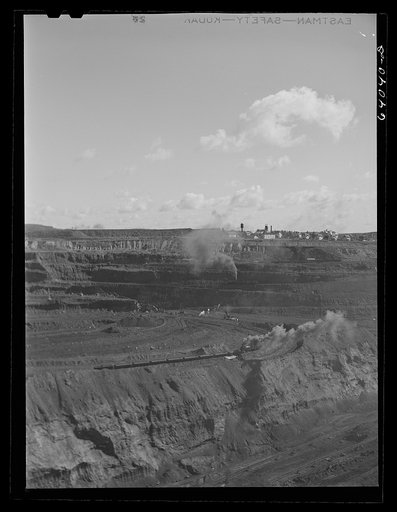World's largest open pit iron mine at Hibbing, Minnesota. The pit is two and a half miles long, three quarters of a mile wide, four hundred feet deep