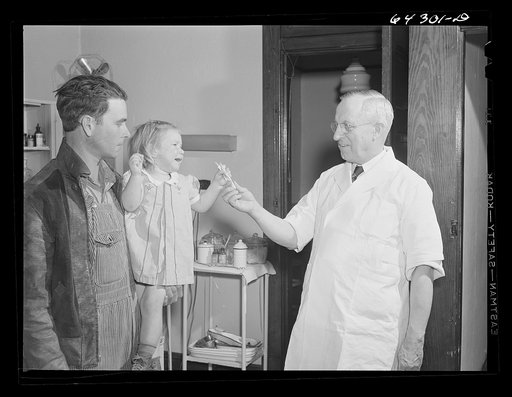 Chaffee, Missouri. Doctor giving little girl a stick of candy. She has just received an injection of anti-hydrophobia vaccine