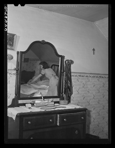 Meeker County, Minnesota. Elaine McCormick, one of the McRaith grandchildren, making the beds in the morning before school bus comes