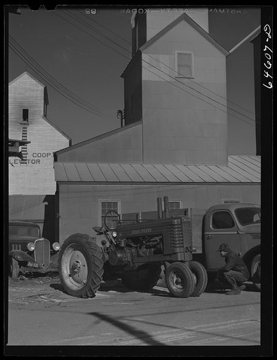 Dawson, Minnesota. Farmer inspecting a tractor