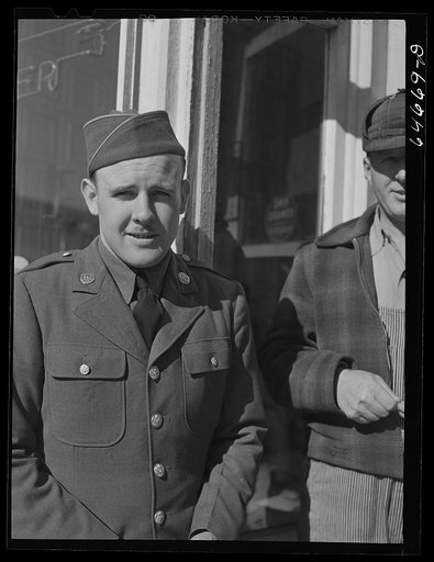 Untitled photo, possibly related to: Bowdle, South Dakota. Soldier on furlough with friends in front of pool hall