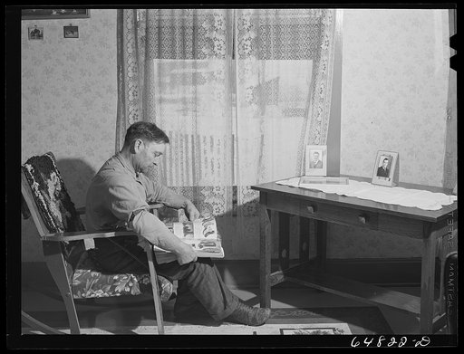 Adams County, North Dakota. George P. Moeller looking through a mail order catalog