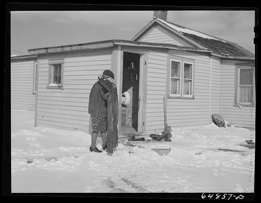 Untitled photo, possibly related to: Adams County, North Dakota. Mrs. Lee Johnson bringing in a pair of overalls which had been drying on the line and have been frozen stiff