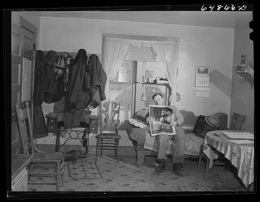 Adams County, North Dakota. Stock farmer, George P. Moeller, reading the Sunday papers