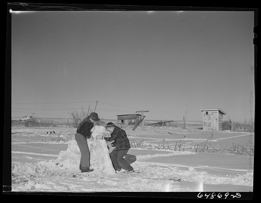 Untitled photo, possibly related to: Dunn Center, North Dakota. Boys building snow fort
