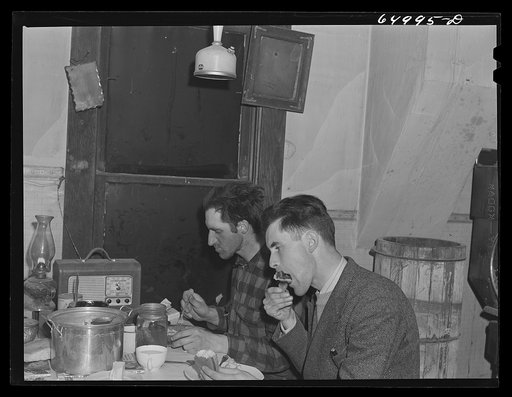 Untitled photo, possibly related to:  Garfield County, Montana. Sheepherder eating in his winter quarters