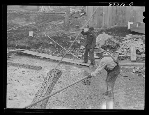 Untitled photo, possibly related to: Kalispell, Montana. Rolling logs into the pond at FSA (Farm Security Administration) cooperative sawmill