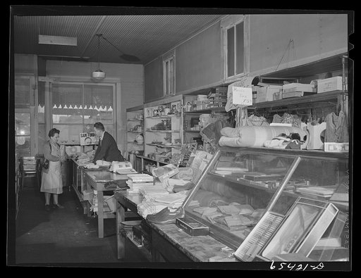 Wisdom, Montana. Len Smith waiting on a customer in the Basin Mercantile Company