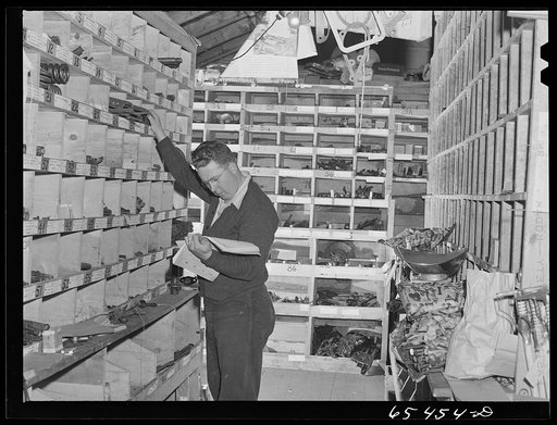 Wisdom, Montana. Len Smith in the stockroom of the Basin Mercantile Company. They have an extremely large stock of tractor and haying machine parts