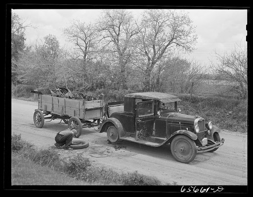 Kearney, Nebraska. Farm boy with flat tire, which happened while he was bringing a load of scrap iron to town