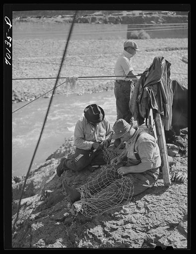 Indian fishermen repairing their nets. Celilo Falls, Oregon. The salmon run was on and fishermen took salmon and sold them to commercial canneries