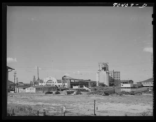 Warehouses and elevators on the waterfront of Astoria, Oregon. Fish and by-products, grain and lumber are shipped from this part