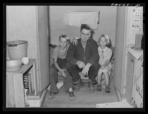 Workman at Umatilla ordnance fepot and his children in homemade trailer. Stanfield, Oregon