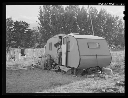 Workman at Umatilla ordnance fepot and his children in homemade trailer. Stanfield, Oregon