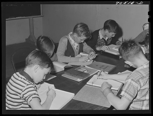 Children of workmen at the Umatilla ordnance depot attend school in basement of church, use long tables as desk. Hermiston, Oregon