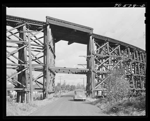 Highway goes under wooden trestle for railroad. Cowlitz County, Washington