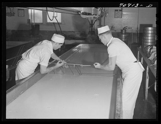 Untitled photo, possibly related to: Breaking up curdling milk is one of the first steps of cheesemaking. Tillamook cheese plant, Tillamook, Oregon. This also distributes evenly the lactic ferment starter