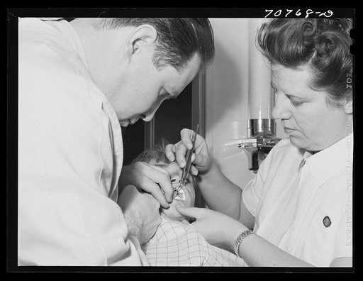 Untitled photo, possibly related to: FSA (Farm Security Administration) dentist and nurse and migrant child in the FSA dental trailer at the FSA camp for farm families. Caldwell, Idaho
