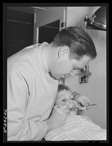 FSA (Farm Security Administration) dentist and migrant child in the FSA dental trailer at the FSA camp for farm families, Caldwell, Idaho