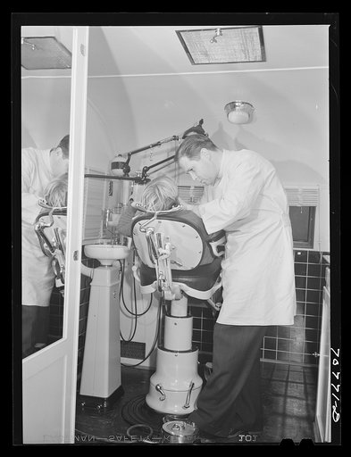 Untitled photo, possibly related to: FSA (Farm Security Administration) dentist and migrant child in the FSA dental trailer at the FSA camp for farm families. At Caldwell, Idaho