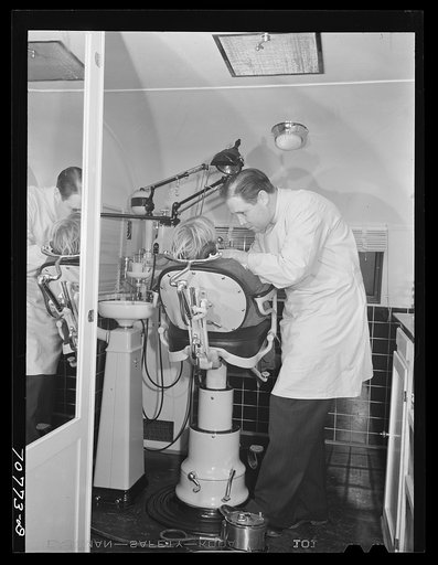 FSA (Farm Security Administration) dentist and migrant child in the FSA dental trailer at the FSA camp for farm families. At Caldwell, Idaho