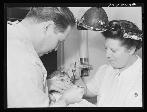 FSA (Farm Security Administration) dentist and nurse and migrant child in the FSA dental trailer at the FSA camp for farm families. Caldwell, Idaho