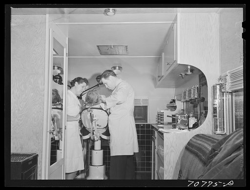 FSA (Farm Security Administration) dentist and nurse and migrant child in the FSA dental trailer at the FSA camp for farm families. Caldwell, Idaho