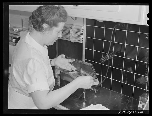 FSA (Farm Security Administration) nurse removes dental instruments from sterilizer in the FSA dental trailer at the FSA camp for farm families