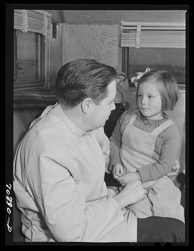 FSA (Farm Security Administration) dentist reassures migrant child who is making her first visit to a dentist. FSA dental trailer at the FSA camp for farm workers. Caldwell, Idaho