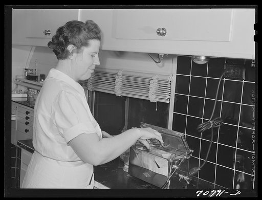 Untitled photo, possibly related to: FSA (Farm Security Administration) nurse removes dental instruments from sterilizer in the FSA dental trailer at the FSA camp for farm families