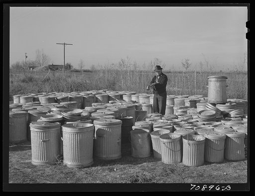 Checking in garbage cans from the FSA (Farm Security Administration) mobile camps at the permanent camp at Caldwell, Idaho, for winter storage