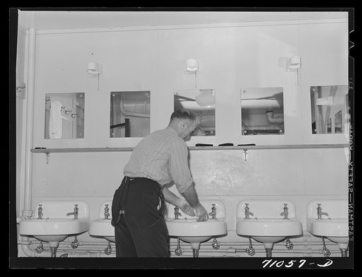 Vallejo, California. Workman at Mare Island shipbuilding yards in bathroom of FSA (Farm Security Administration) dormitory