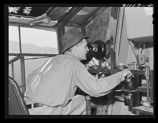 Man in control tower at Shasta Dam. Shasta County, California. He directs the various cable cars, equiptment which transports materials to construction points