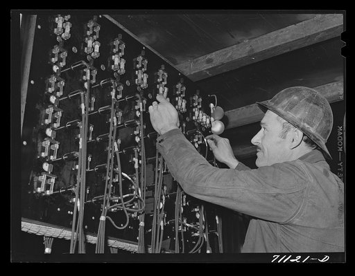 Workman at telephone switchboard. Shasta Dam, Shasta County, California. Various areas of construction are connected with telephone connections