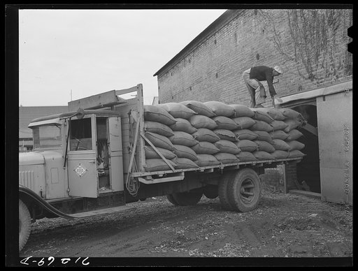Petaluma, Sonoma County, California. Loading feed onto a truck at a warehouse