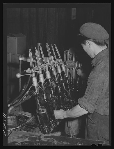 Untitled photo, possibly related to: Sonoma County, California. Filling bottles with wine at the winery