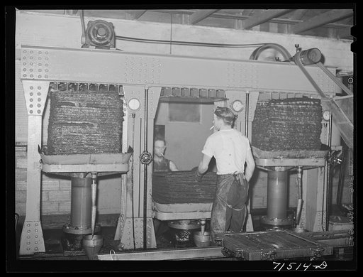 Untitled photo, possibly related to: Bags full of olive pulp in hydraulic presses for extraction of oil. The pulp is pressed two different times under differet degrees of pressure and this produces two distinct qualities of oil. Lindsay, California