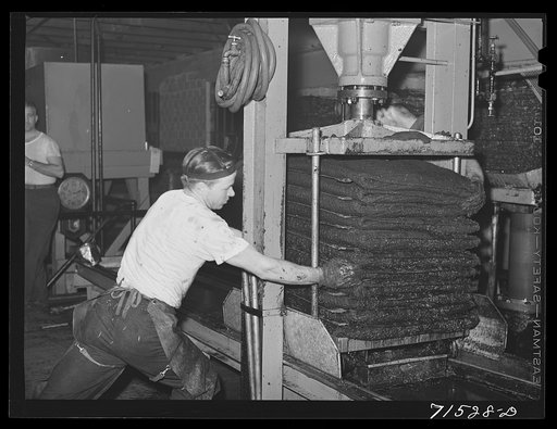 Hydraulic pressure is applied to bags of crushed olives to force out the oil. The first pressing extracts about seventy-five percent of the entire oil content. This is fine virgin olive oil. Lindsay, California