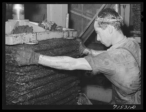 Olive pulp under hydraulic pressure for extraction of oil. Lindsay, California