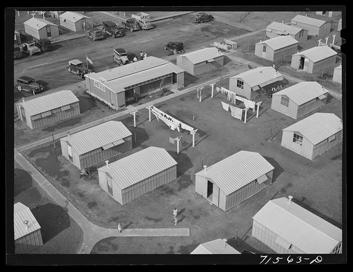 Woodville, California. FSA (Farm Security Administration) farm workers' community. Metal shelters are grouped about the utility building