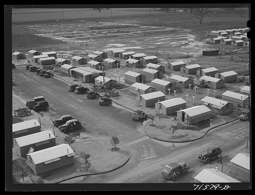 Woodville, California. FSA (Farm Security Administration) farm workers' community. Metal shelters for migrant agricultural workers are grouped about the utility building