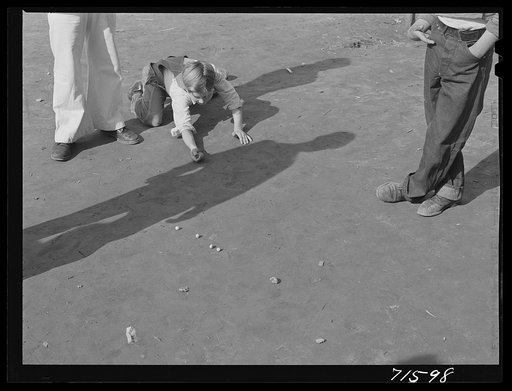 Woodville, California. FSA (Farm Security Administration) farm workers' community. Sons of migrant agricultural workers playing marbles