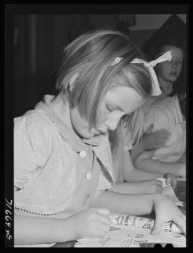 Tulare County, California. FSA (Farm Security Administration) farm workers' camp. Girls reading a copy of Popular mechanics