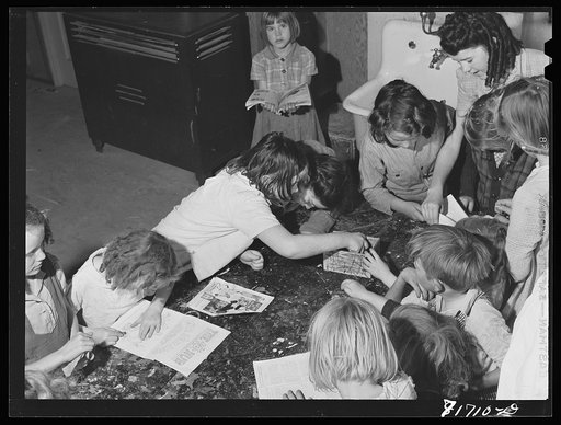 Untitled photo, possibly related to: Tulare County, California. FSA (Farm Security Administration) farm workers' camp. Girls reading a copy of Popular mechanics